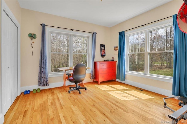 home office featuring baseboards, healthy amount of natural light, and wood finished floors