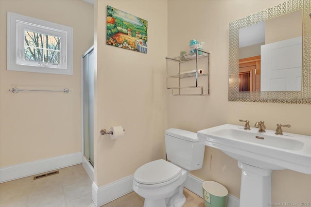 full bathroom with toilet, a shower stall, baseboards, and a sink