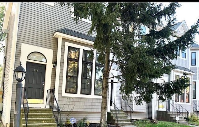 entrance to property with roof with shingles