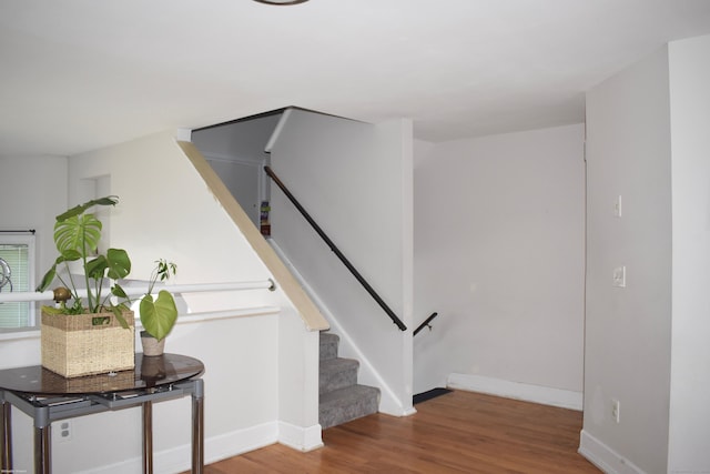 staircase featuring baseboards and wood finished floors