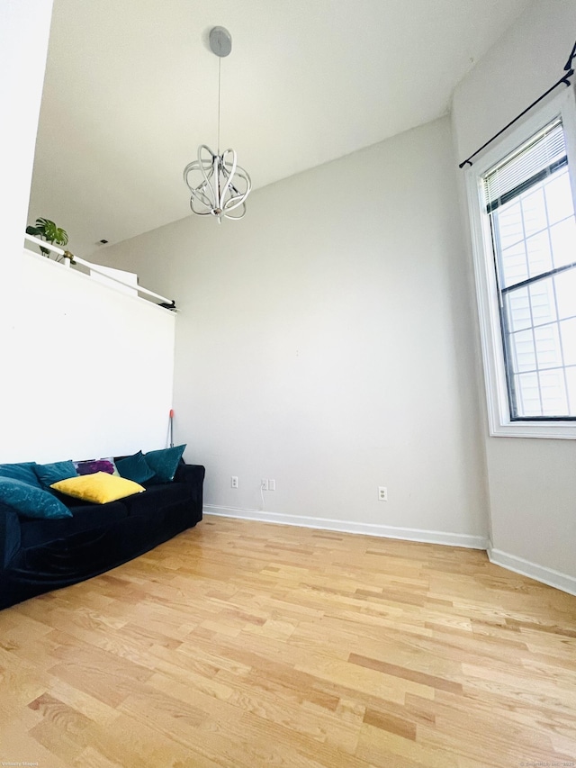 interior space featuring light wood finished floors, baseboards, and a chandelier