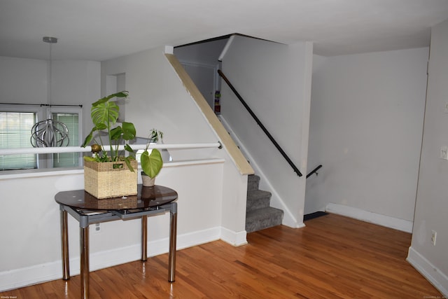 stairway with wood finished floors and baseboards