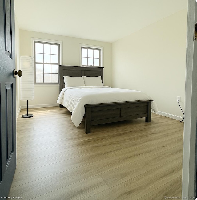 bedroom featuring baseboards and light wood-style floors