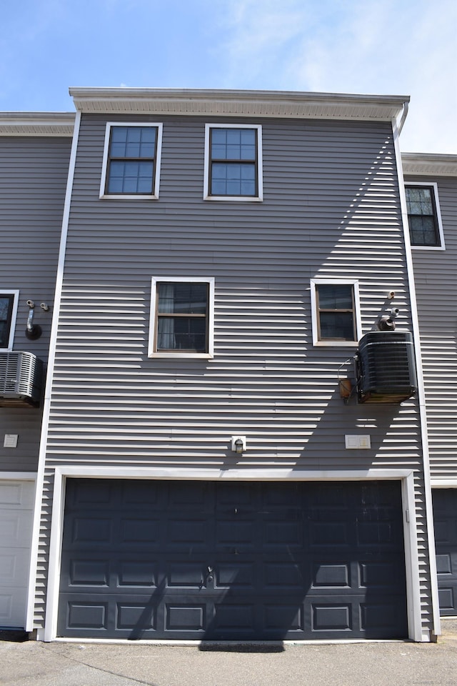 view of side of home featuring an attached garage and central air condition unit