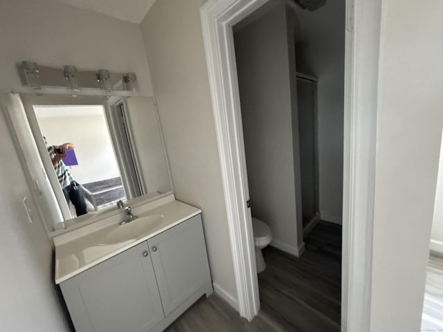 full bathroom with toilet, baseboards, wood finished floors, a shower stall, and vanity