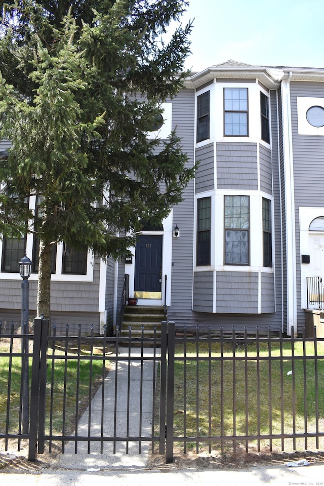 view of front of property with entry steps and a fenced front yard
