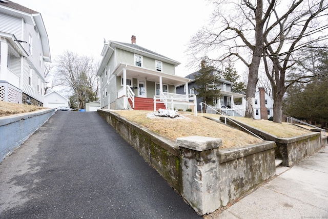 87 Englewood Ave, Waterbury, CT 06705 - view of front of house featuring a chimney, an outbuilding, a detached garage, and covered porch