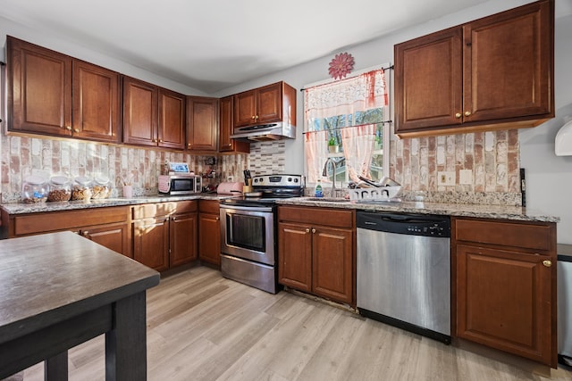 87 Englewood Ave, Waterbury, CT 06705 - kitchen featuring stainless steel appliances, light wood-style flooring, tasteful backsplash, light stone counters, and under cabinet range hood