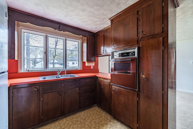 33 Wagon Rd, Enfield, CT 06082 - kitchen featuring wall oven, a sink, a textured ceiling, dark brown cabinets, and light countertops