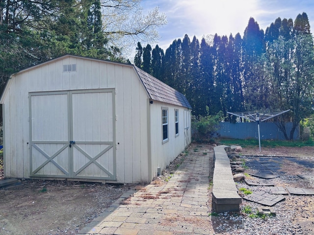 view of shed featuring fence