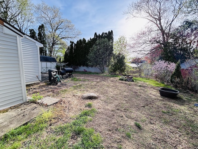 view of yard featuring a storage unit, a fenced backyard, and an outbuilding