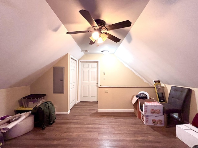 bonus room featuring wood finished floors, a ceiling fan, electric panel, baseboards, and lofted ceiling