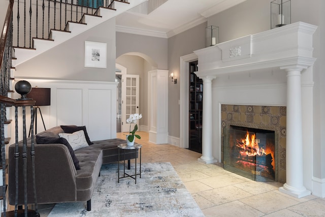 17 Wardwell Dr, New Canaan, CT 06840 - living area featuring stone tile floors, ornamental molding, a fireplace, arched walkways, and stairs