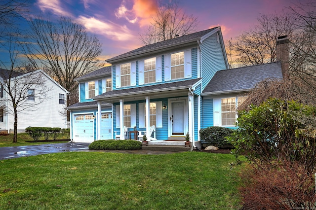 63 Chestnut Ln, Milford, CT 06461 - traditional-style home with a porch, a garage, a shingled roof, a front yard, and aphalt driveway