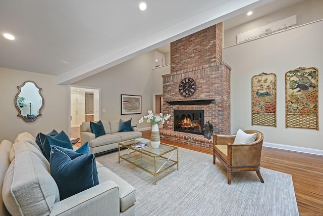 living area featuring wood finished floors, baseboards, a brick fireplace, recessed lighting, and high vaulted ceiling