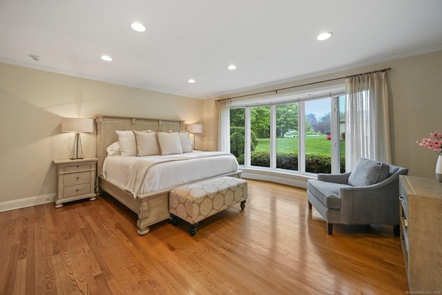 bedroom with ornamental molding, light wood-style floors, recessed lighting, and baseboards