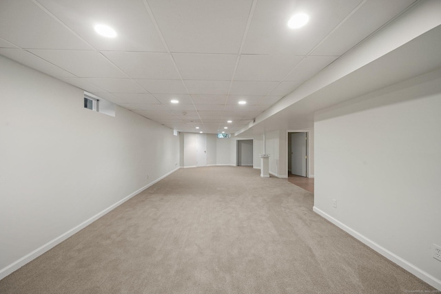 finished basement with light colored carpet, baseboards, recessed lighting, and a drop ceiling