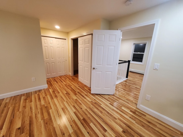 spare room featuring recessed lighting, baseboards, and light wood-type flooring
