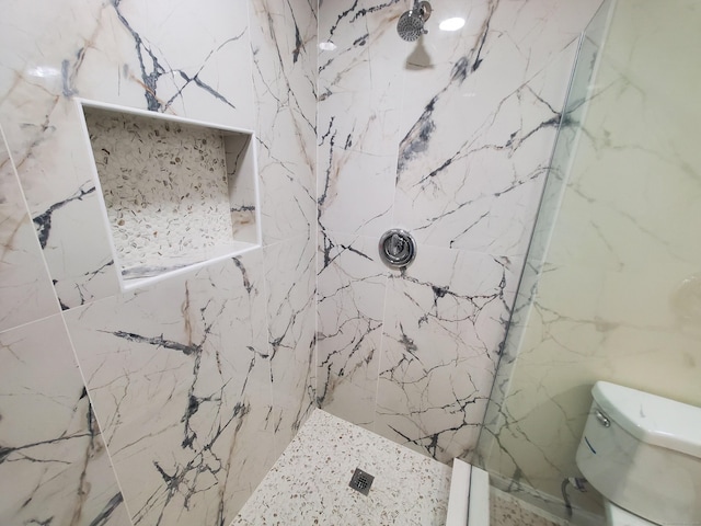 bathroom featuring tile walls, a marble finish shower, and toilet