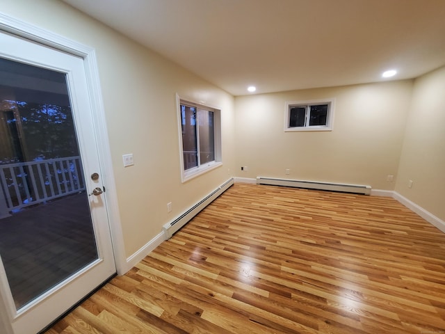spare room with baseboards, recessed lighting, a baseboard heating unit, and light wood finished floors