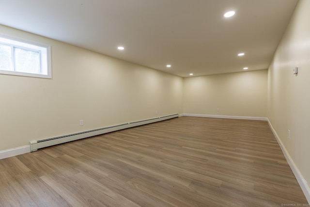 below grade area with a baseboard radiator, wood finished floors, and recessed lighting