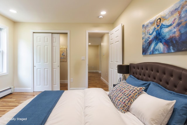 bedroom featuring recessed lighting, a closet, baseboards, baseboard heating, and wood finished floors