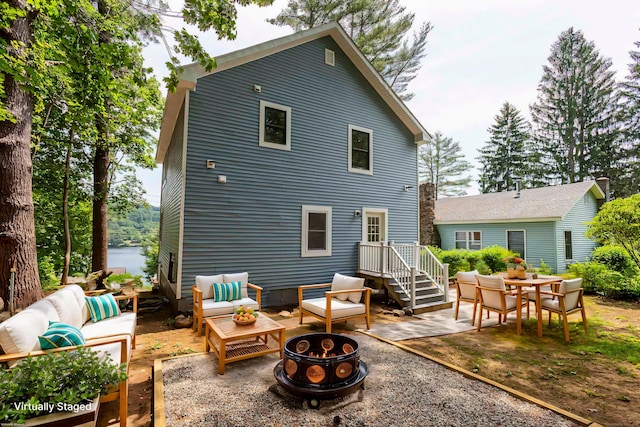 rear view of house featuring an outdoor living space with a fire pit and a patio area