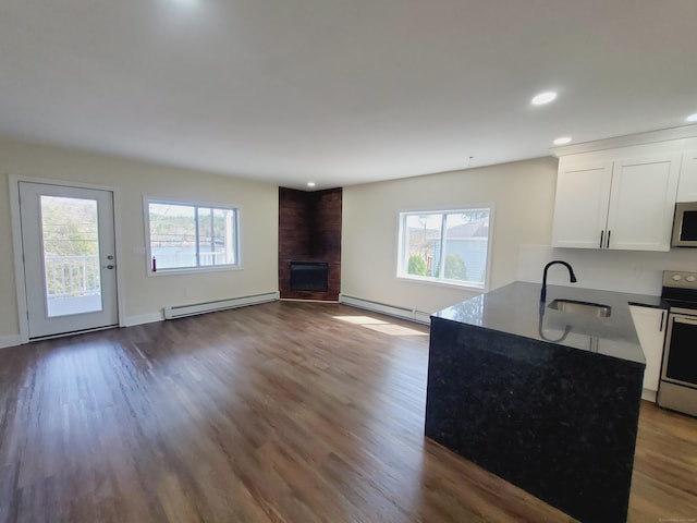 kitchen featuring white cabinets, a sink, a baseboard radiator, stainless steel appliances, and baseboard heating
