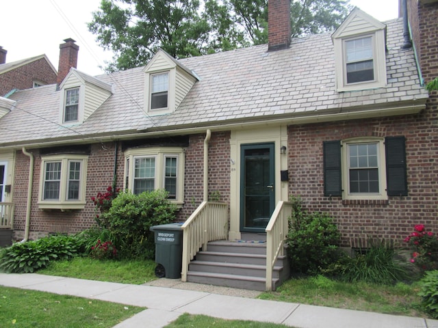 164 Flanders St, Bridgeport, CT 06604 - new england style home featuring brick siding, a chimney, and a high end roof