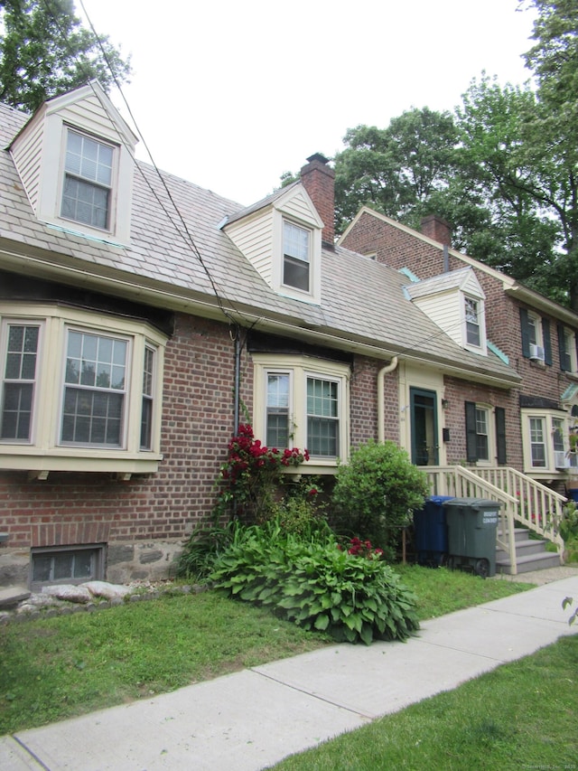 164 Flanders St, Bridgeport, CT 06604 - view of front facade with a chimney, brick siding, and a front yard
