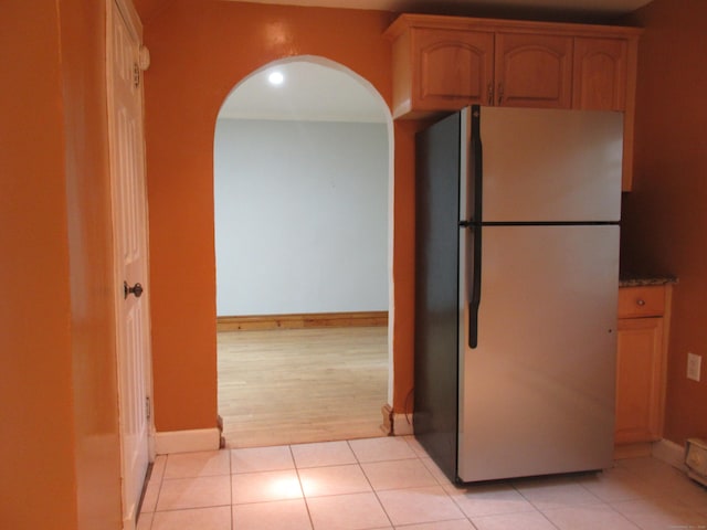 164 Flanders St, Bridgeport, CT 06604 - kitchen with freestanding refrigerator, arched walkways, baseboards, and light tile patterned flooring