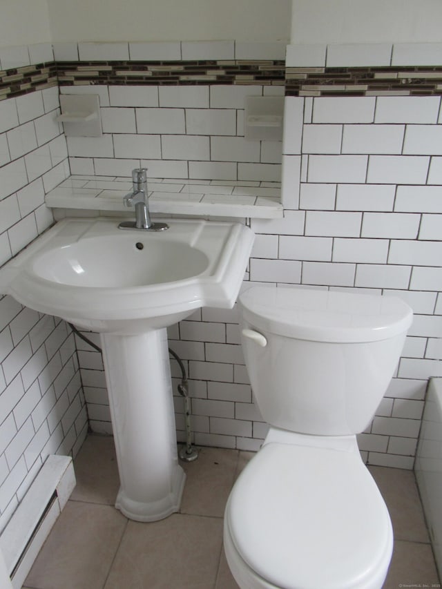 164 Flanders St, Bridgeport, CT 06604 - bathroom featuring tile walls, toilet, tile patterned flooring, and a sink