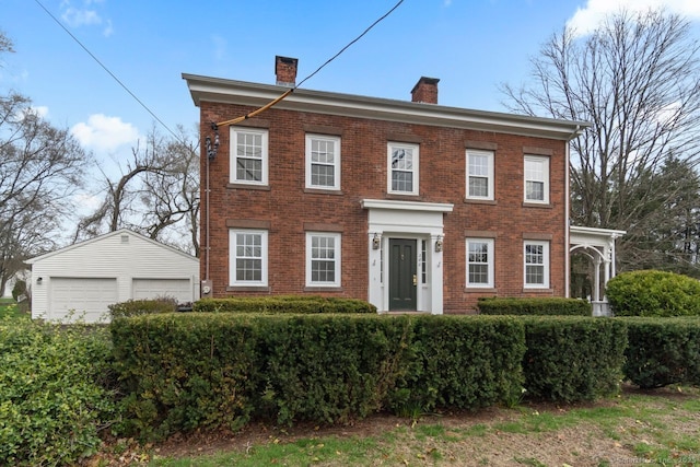 280 Mill Rd, North Haven, CT 06473 - view of front of house with a chimney, brick siding, a garage, and an outdoor structure