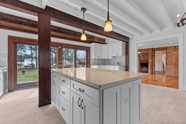 280 Mill Rd, North Haven, CT 06473 - kitchen with beam ceiling, plenty of natural light, white cabinets, a kitchen island, and a brick fireplace