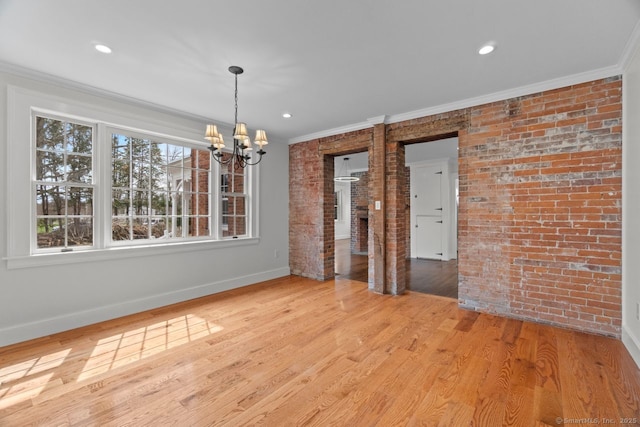 280 Mill Rd, North Haven, CT 06473 - unfurnished dining area featuring brick wall, a chandelier, crown molding, baseboards, and wood finished floors
