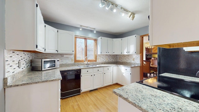 kitchen featuring light wood-type flooring, white cabinetry, black appliances, a sink, and backsplash