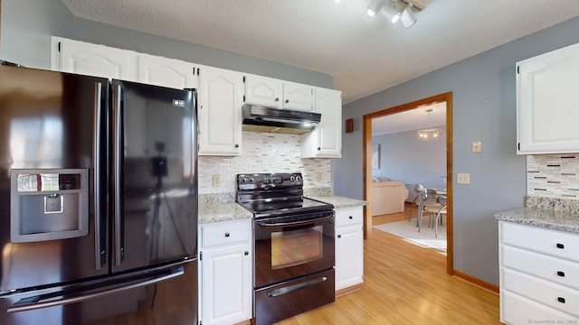 kitchen featuring white cabinets, under cabinet range hood, black appliances, and backsplash