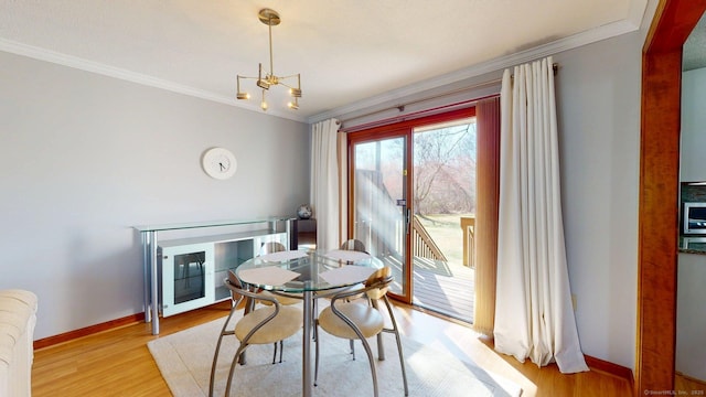 dining area with crown molding, baseboards, and light wood finished floors
