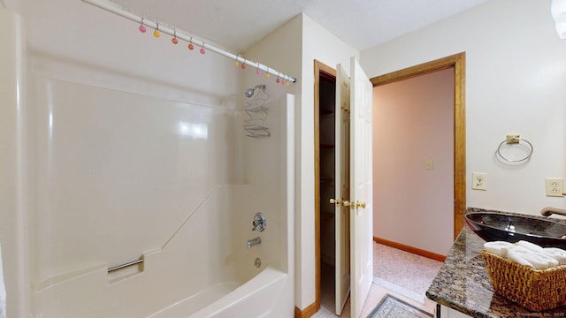 bathroom with a sink, baseboards, and shower / bath combination