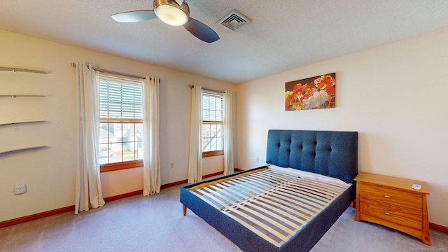 carpeted bedroom featuring visible vents, baseboards, and a ceiling fan