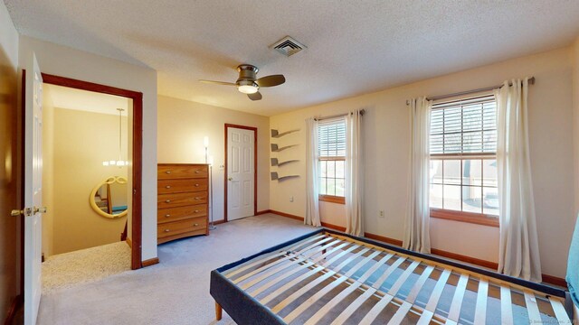 unfurnished bedroom with baseboards, a textured ceiling, a ceiling fan, visible vents, and carpet