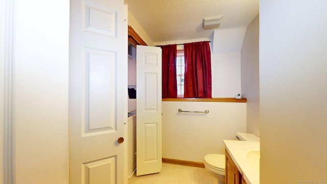 half bath featuring a textured ceiling, vanity, visible vents, toilet, and baseboards