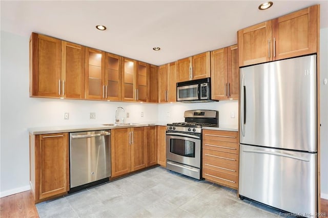 32 Pine St Unit 6, Norwalk, CT 06854 - kitchen with a sink, brown cabinetry, light countertops, and stainless steel appliances