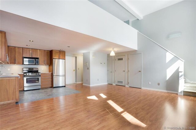 32 Pine St Unit 6, Norwalk, CT 06854 - kitchen featuring a sink, light countertops, appliances with stainless steel finishes, brown cabinets, and light wood finished floors