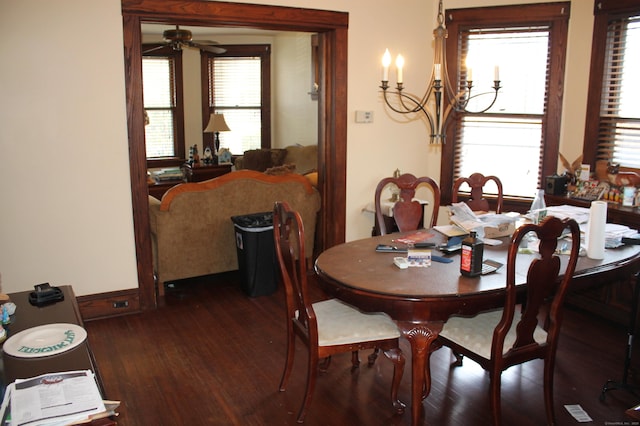 dining space featuring wood finished floors and ceiling fan with notable chandelier