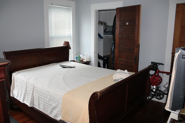 bedroom with wood finished floors and a closet