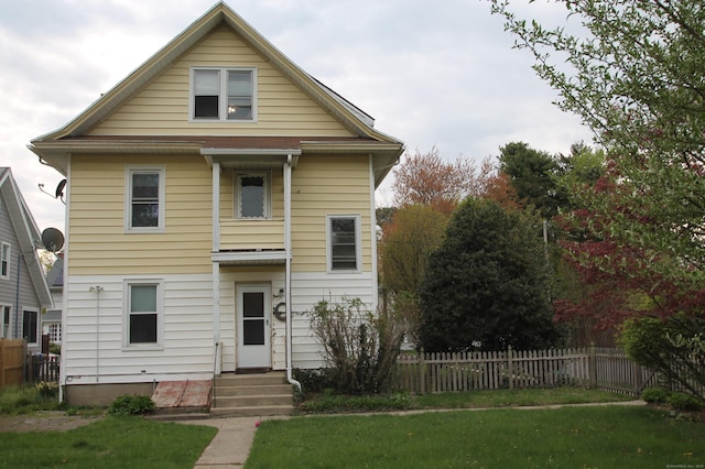 view of front facade with fence, entry steps, and a front yard