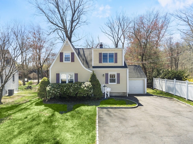 view of front of property featuring central AC, a chimney, a front lawn, driveway, and fence