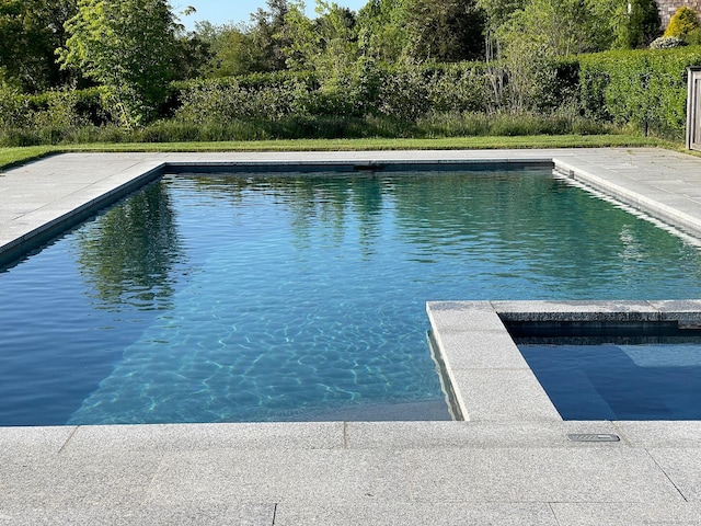 view of pool with a patio and a pool with connected hot tub
