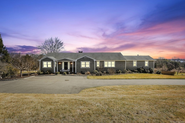 single story home with curved driveway and a front lawn